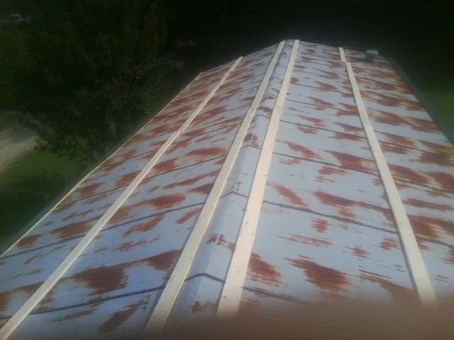 Rusted metal roof panels with new wood purlins before replacement — Storm Damage Roof Repair in Parkersburg by Roofing Brothers