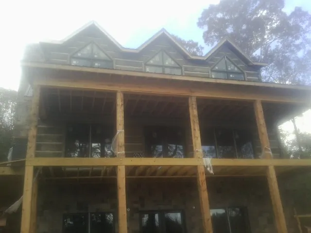 Dormers and porch framing on a large log home under construction — Roof Coating work by our crew in Parkersburg