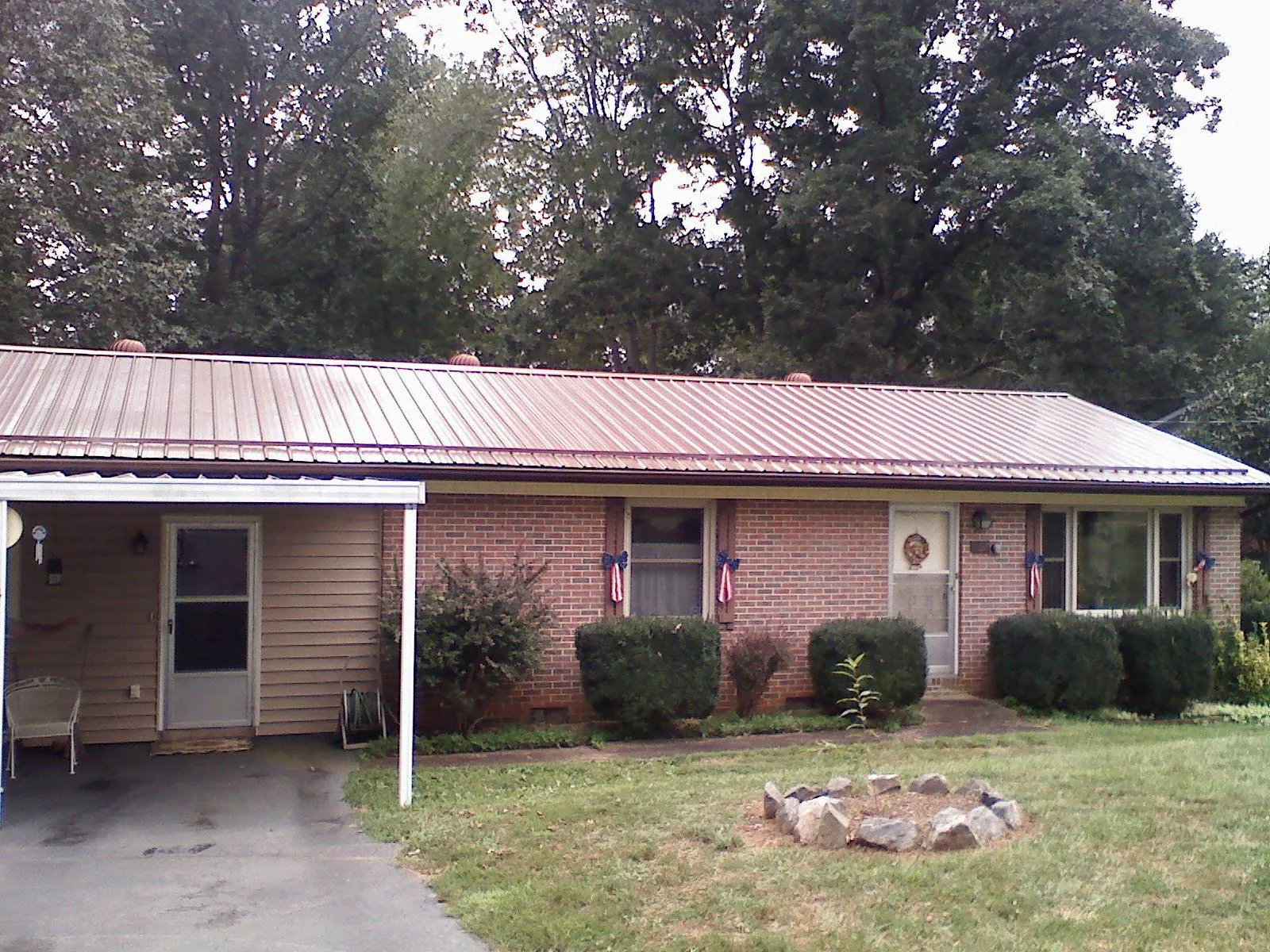 Bronze metal roof and carport on a brick ranch home — Roof Repair work by our crew in Parkersburg